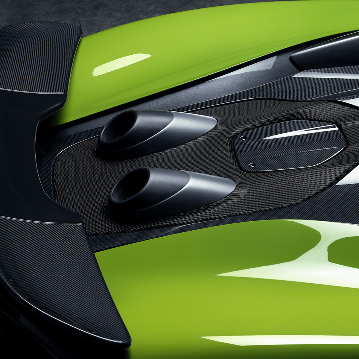 Close up of the exhaust and surrounding carbon fibre detail on a bright green McLaren 600LT Spider.
