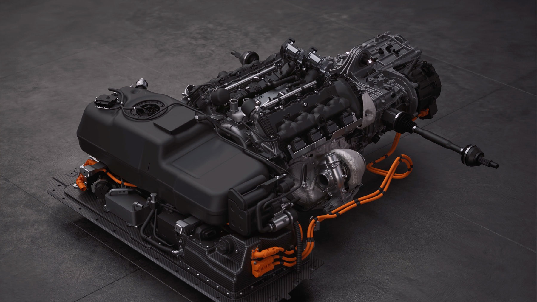  A detailed overhead shot of a complex McLaren powertrain, featuring a large internal combustion engine, electric components, and orange high-voltage cables, all mounted on a carbon fiber base.