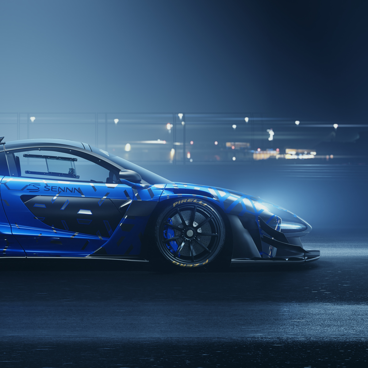 Side view of a blue patterned McLaren Senna GTR parked in a urban setting at night with headlights on.