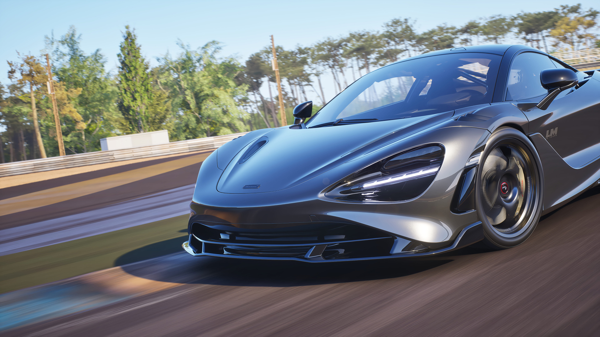 A dynamic low-angle shot of a grey McLaren 750S Le Mans edition on a racetrack, showcasing its headlights and 'LM' side badge against a blurred background.