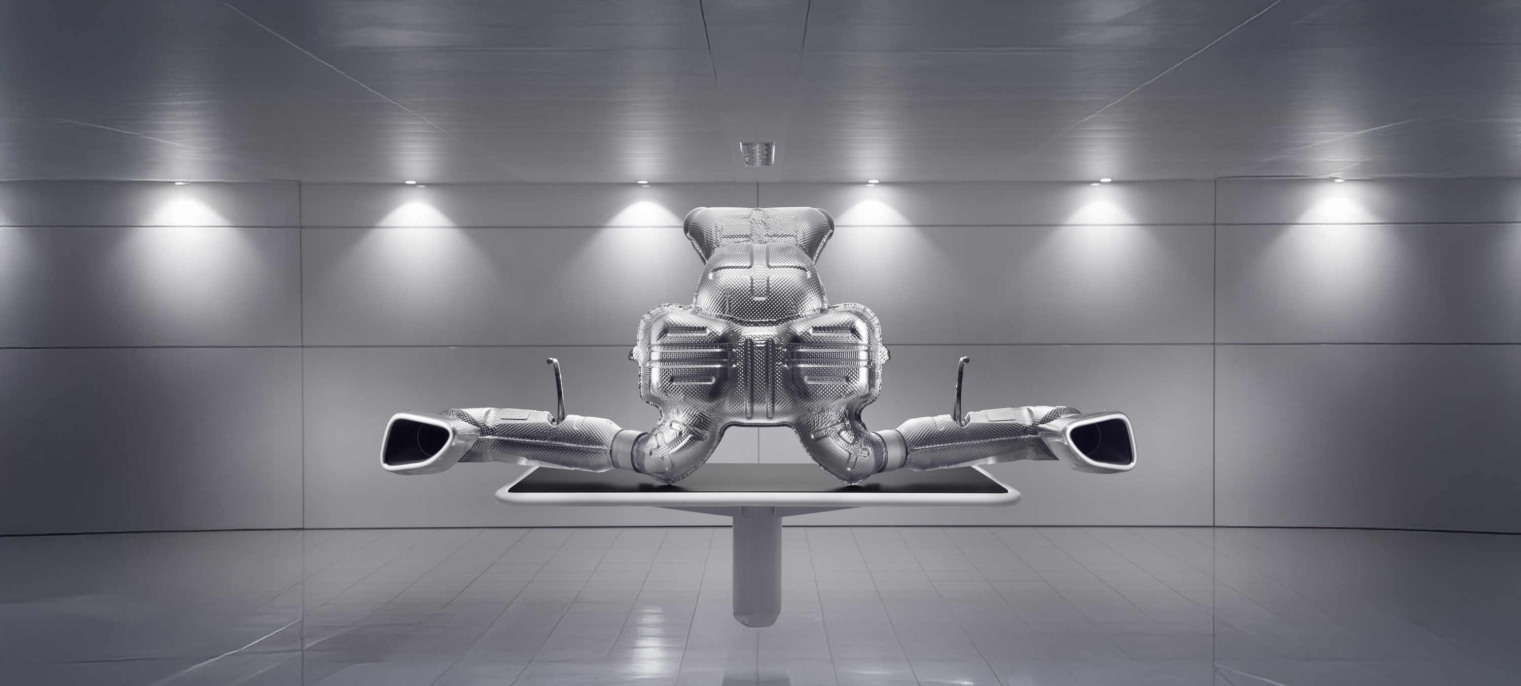 A large, detailed image of a McLaren exhaust system and muffler, on display in a clean, modern setting.