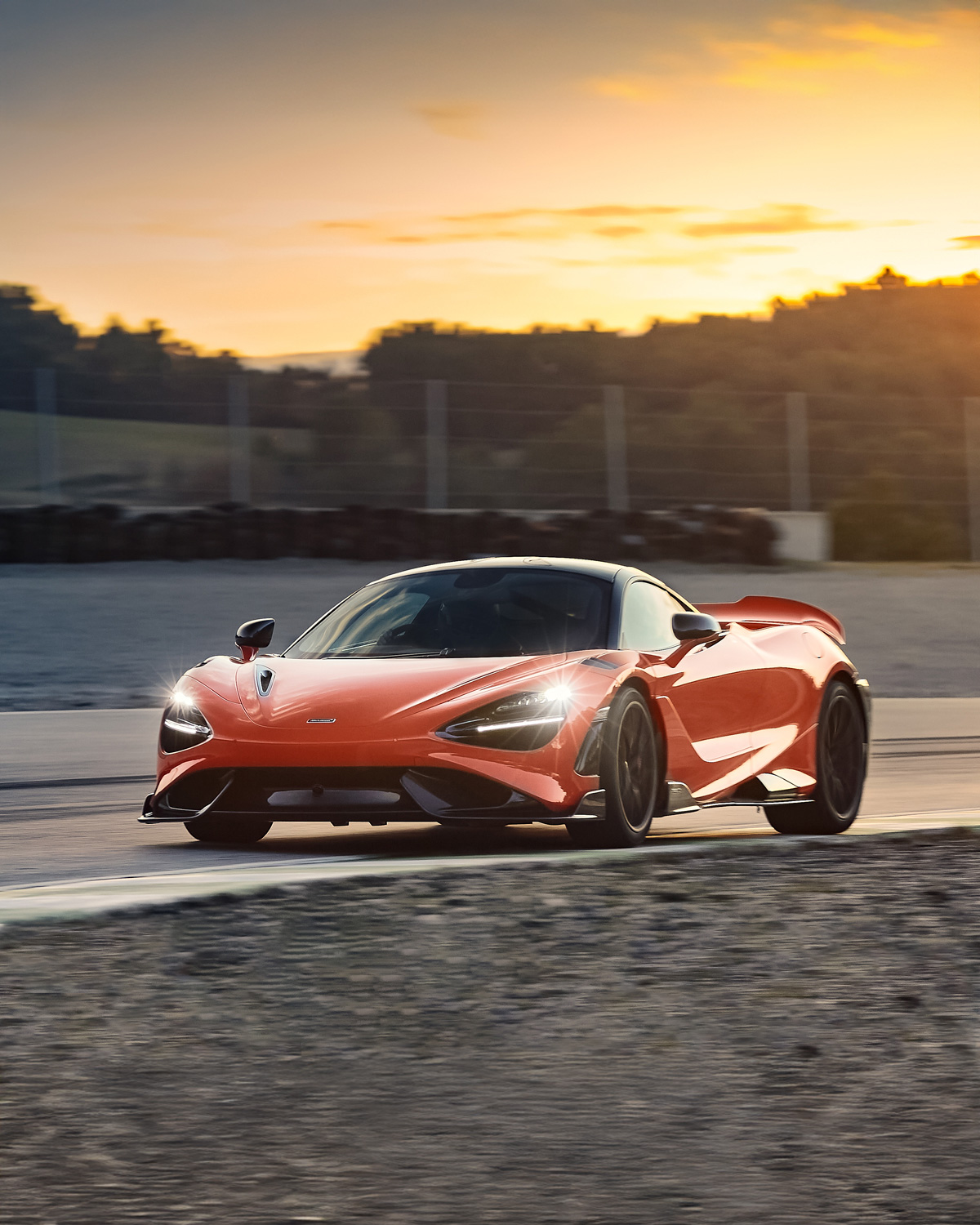 Orange McLaren 765LT driving around a track at speed.