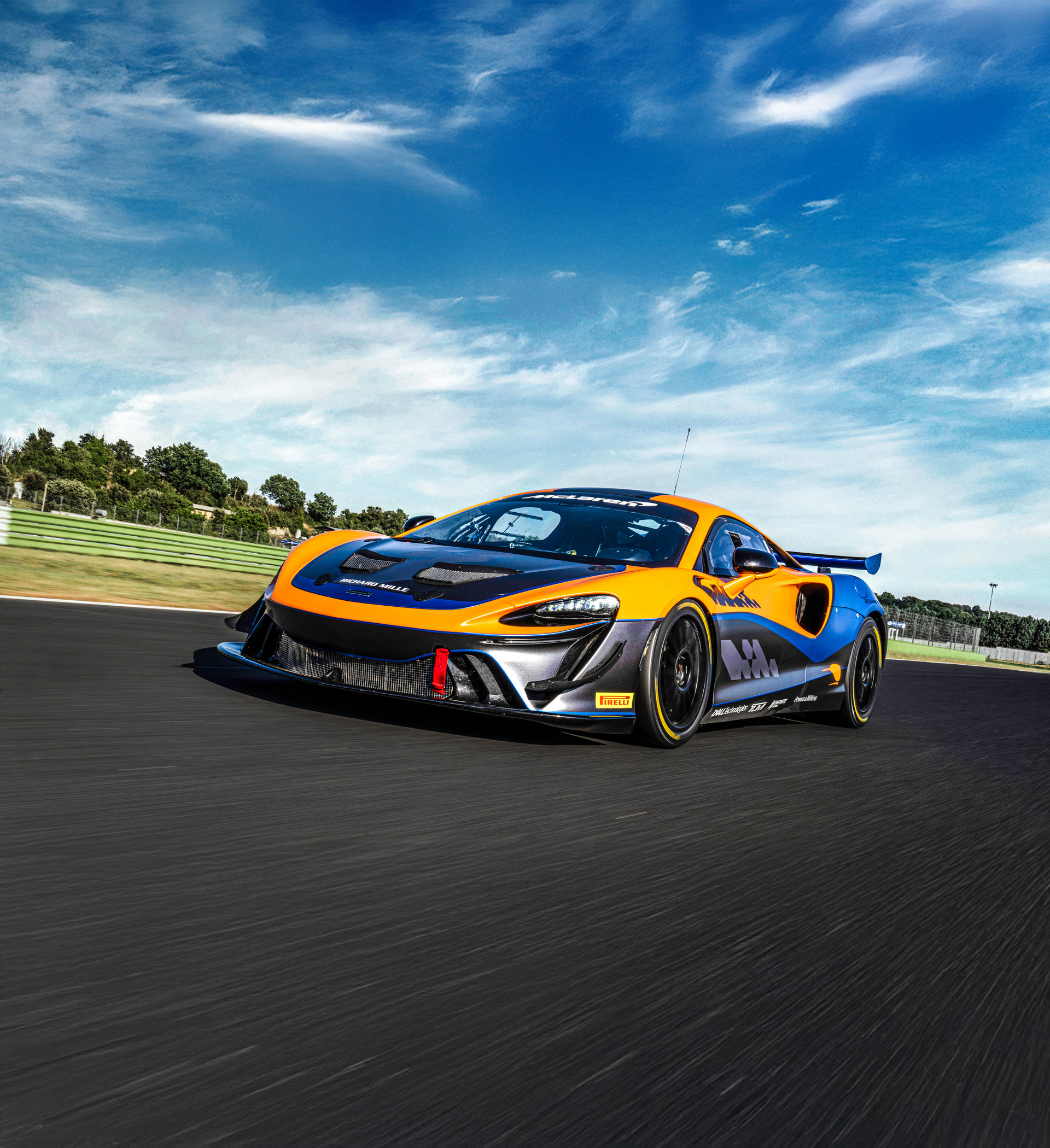 McLaren Artura GT4 driving around a race track at speed.