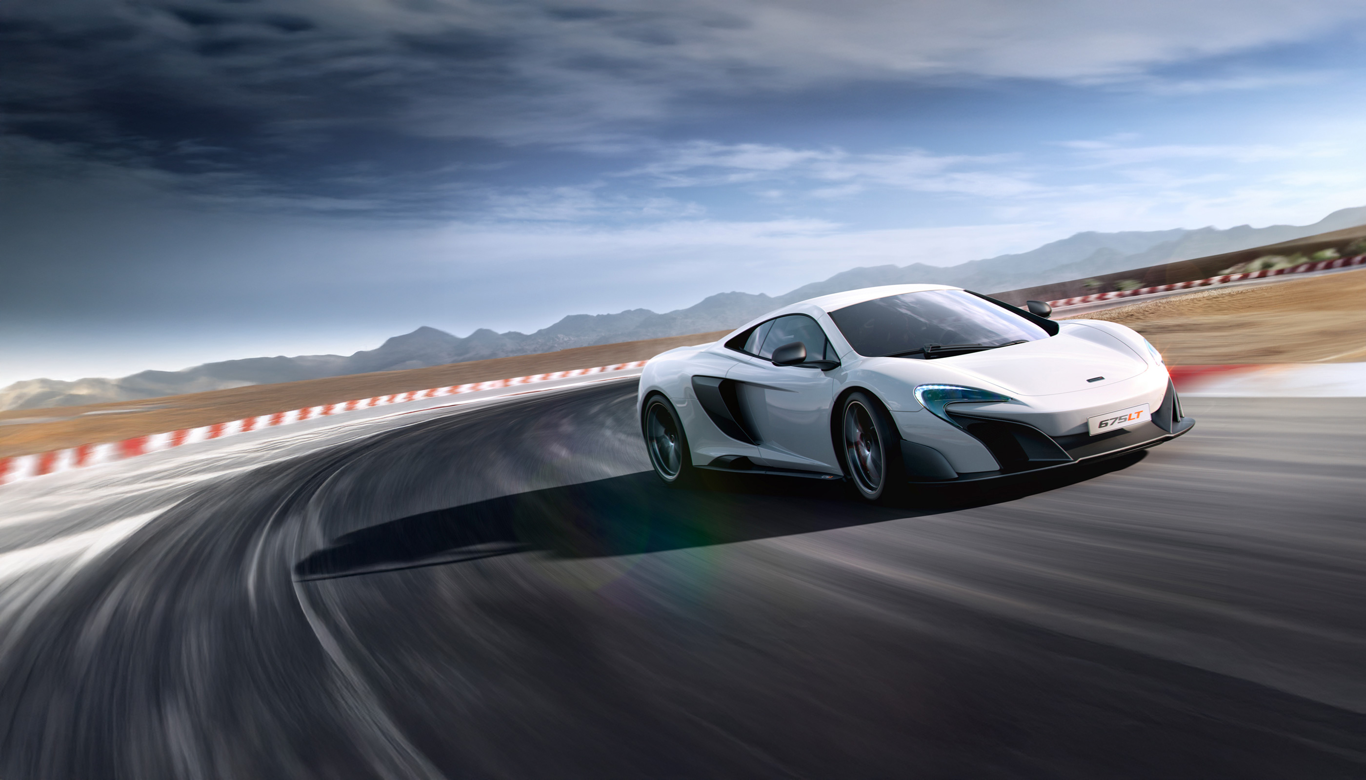 A dynamic action shot of a white McLaren 675LT sports car, speeding around a wide curve on a racetrack.
