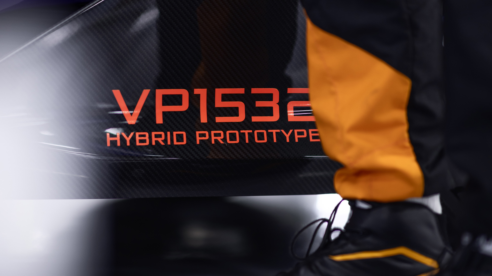 A detailed shot of a orange label on the carbon fibre side of a McLaren W1 prototype that reads "VP1532 Hybrid Prototype".