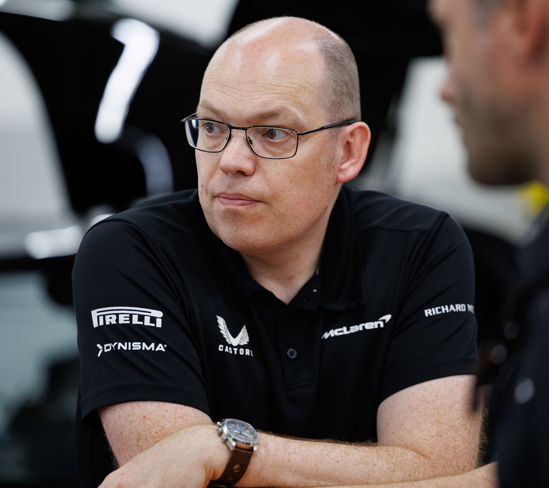 Close-up portrait of Andy Beale wearing a black McLaren technical shirt with sponsor logos (Pirelli, Castore). Image details an engineer/manager involved in the McLaren W1 development and extreme testing program.