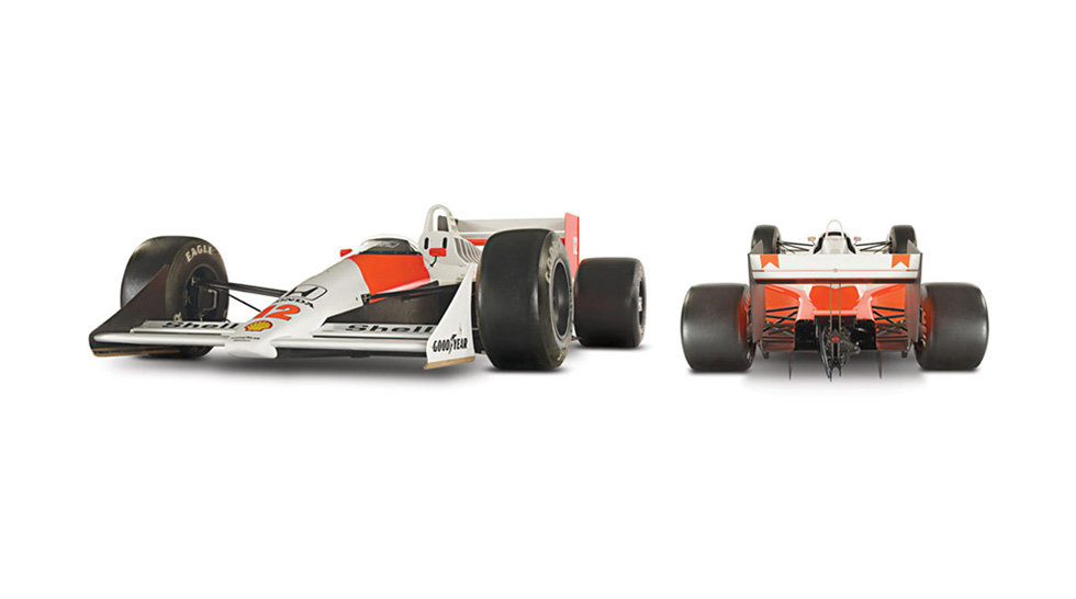 Front side and back view of the red and white McLaren MP4/4, covered in sponsorship logos and with the number 12 painted on the body. Shown on a white background.