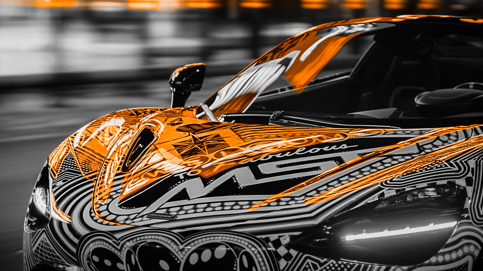Extreme close-up of the front clamshell of the MSO Project Viva 750S, showing the intricate hand-painted design and the 'To Fabulous MSO' text accented with McLaren orange lighting.