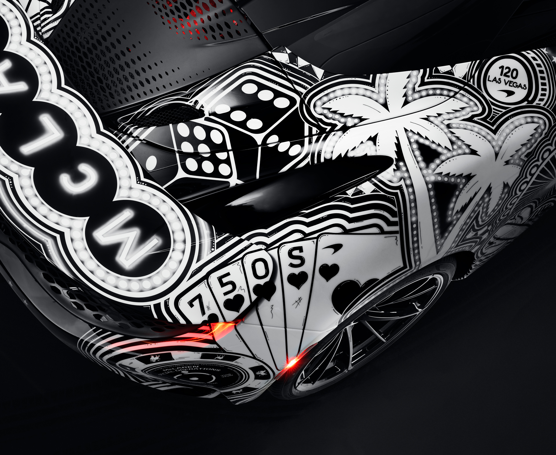 Close-up of the rear bodywork of the MSO Project Viva showing detailed, hand-painted Las Vegas motifs including casino dice, a palm tree, and playing cards with a 750S emblem, blending art with McLaren performance.
