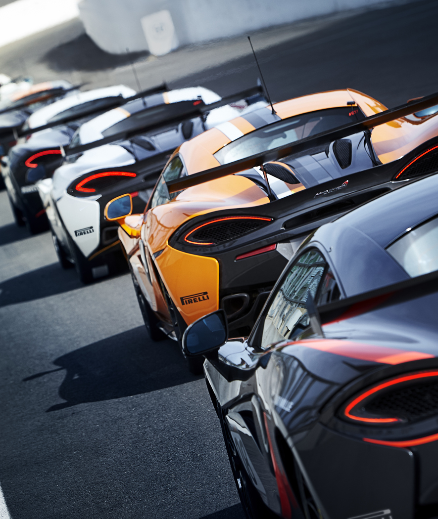 A queue of cars, all from the Pure McLaren GT Series, lined up on a race track.